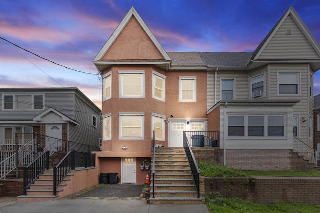 99 W 50th St, Bayonne, NJ 07002 - townhome / multi-family property featuring stairway, stucco siding, and cooling unit