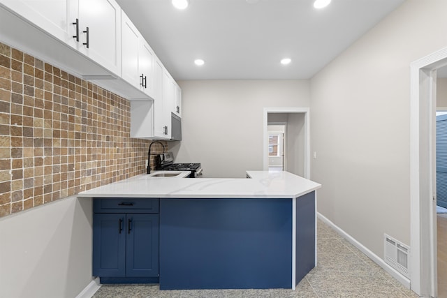 99 W 50th St, Bayonne, NJ 07002 - kitchen with a peninsula, recessed lighting, white cabinetry, tasteful backsplash, and baseboards