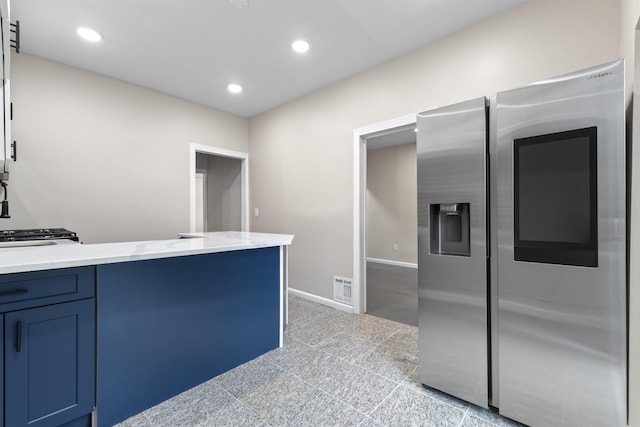 99 W 50th St, Bayonne, NJ 07002 - kitchen with recessed lighting, stainless steel refrigerator with ice dispenser, light stone countertops, blue cabinetry, and baseboards