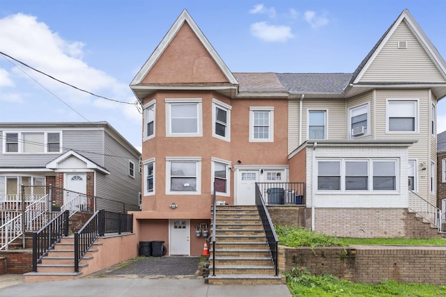 99 W 50th St, Bayonne, NJ 07002 - townhome / multi-family property featuring stairway, cooling unit, and stucco siding