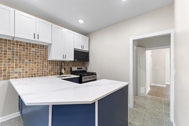 99 W 50th St, Bayonne, NJ 07002 - kitchen with stainless steel gas range oven, a sink, light stone countertops, decorative backsplash, and white cabinetry