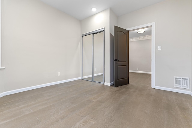 99 W 50th St, Bayonne, NJ 07002 - unfurnished bedroom with wood finished floors, baseboards, and a closet