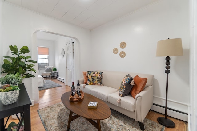 living room featuring ornamental molding, cooling unit, baseboard heating, and light hardwood / wood-style floors