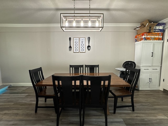 dining space featuring ornamental molding, dark wood-style flooring, a textured ceiling, and baseboards