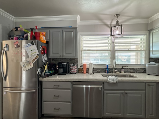 kitchen with stainless steel appliances, a healthy amount of sunlight, a sink, and decorative backsplash