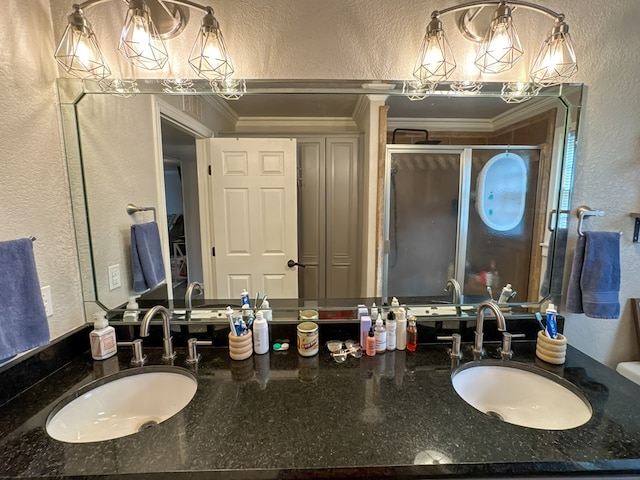 full bathroom featuring a shower stall, vanity, crown molding, and a textured wall