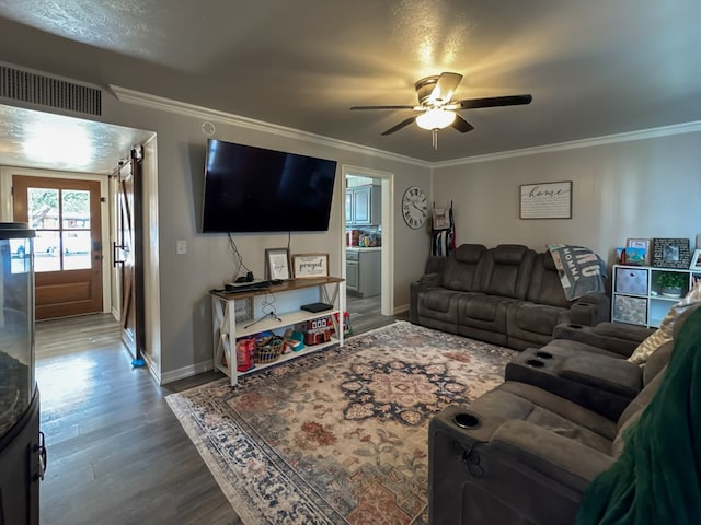 living area featuring wood finished floors, visible vents, and crown molding