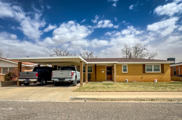 ranch-style house with concrete driveway, a front yard, a carport, and brick siding