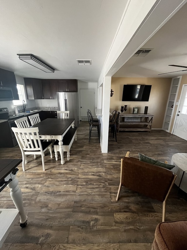 dining room featuring ceiling fan, dark hardwood / wood-style floors, and sink