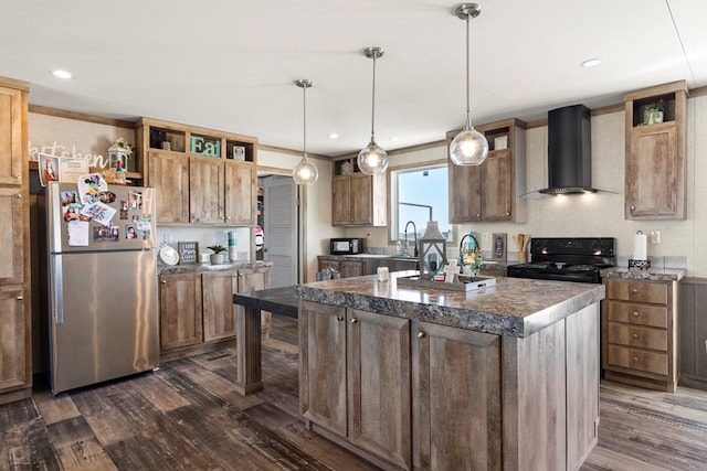 kitchen with electric range, dark countertops, a kitchen island, freestanding refrigerator, and wall chimney range hood