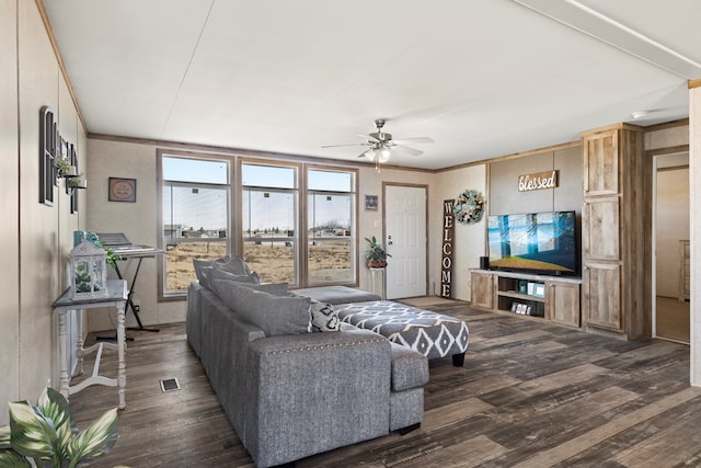 living room featuring dark wood-style floors, ceiling fan, visible vents, and crown molding