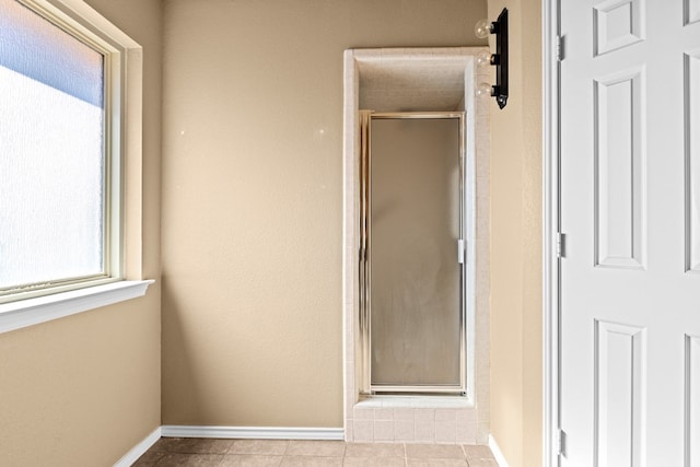 bathroom featuring a shower with shower door and tile patterned floors