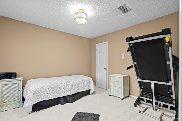 bedroom with light colored carpet and a textured ceiling