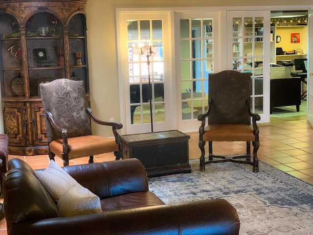 sitting room with tile patterned floors, a notable chandelier, and french doors