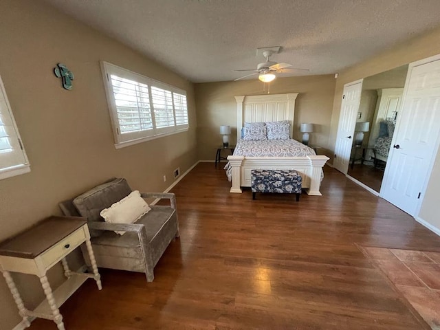 bedroom with ceiling fan, dark hardwood / wood-style flooring, and a textured ceiling