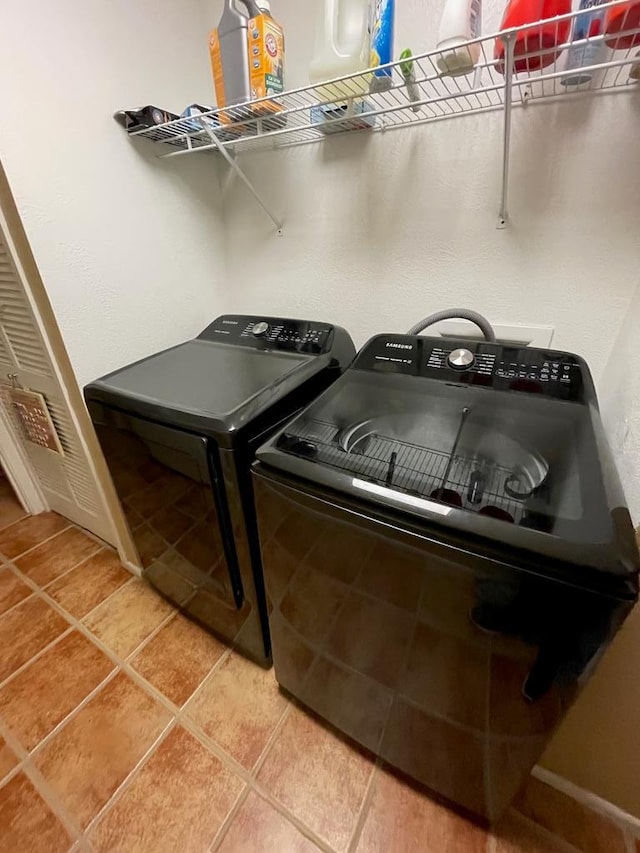 washroom featuring tile patterned flooring and washing machine and dryer