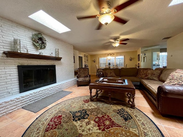 tiled living room featuring ceiling fan, brick wall, a textured ceiling, and a brick fireplace