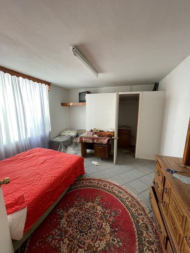 bedroom featuring light tile patterned flooring and a textured ceiling