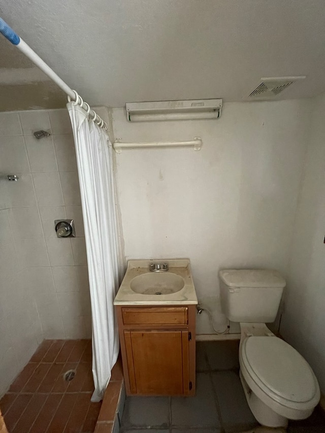 bathroom featuring tile patterned floors, vanity, toilet, and curtained shower