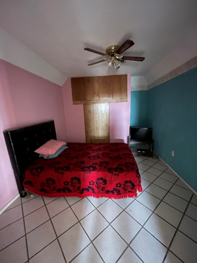 tiled bedroom with ceiling fan and lofted ceiling