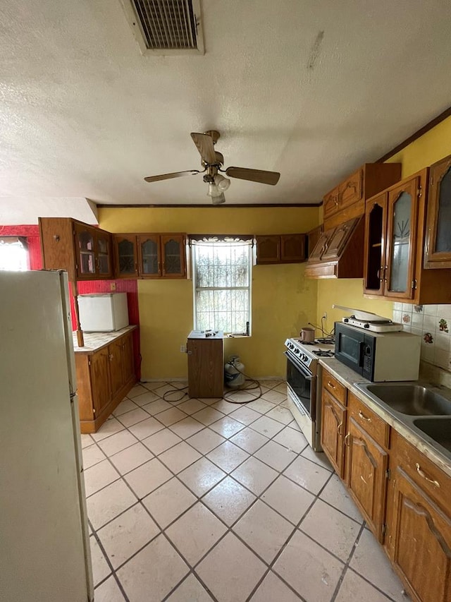 kitchen with ceiling fan, tasteful backsplash, white appliances, light tile patterned floors, and custom exhaust hood