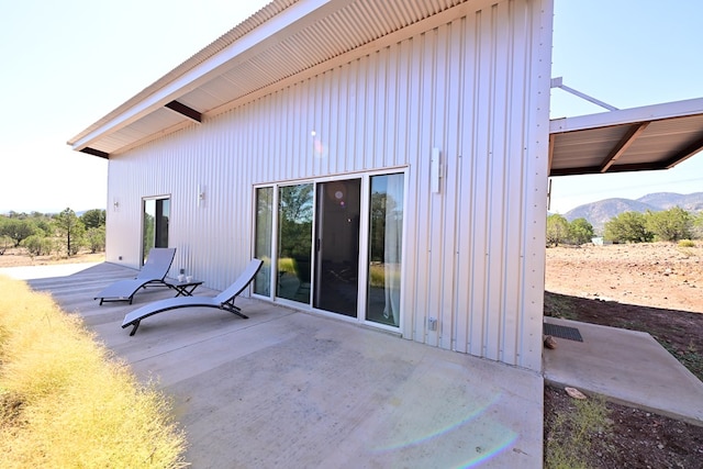 rear view of property featuring a mountain view and a patio