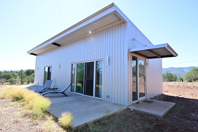 back of house featuring a mountain view and a patio