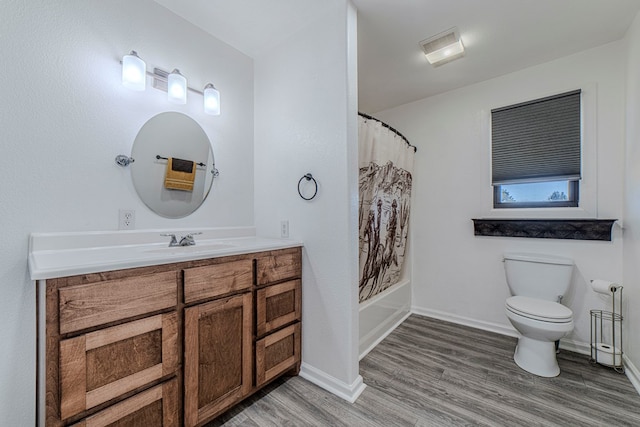 full bathroom featuring vanity, hardwood / wood-style floors, shower / bathtub combination with curtain, and toilet