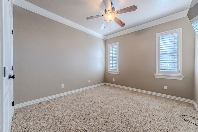 carpeted spare room featuring a wealth of natural light, crown molding, and ceiling fan