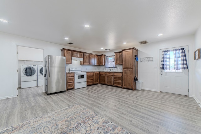 kitchen with stainless steel fridge, electric range, light hardwood / wood-style floors, and independent washer and dryer