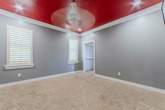 empty room featuring carpet flooring, crown molding, ceiling fan, and a textured ceiling