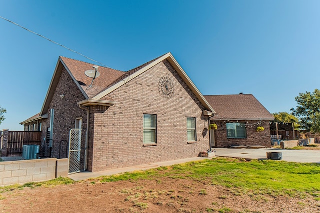 rear view of property with a lawn, central AC, and a patio area