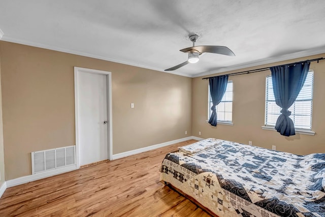 bedroom with hardwood / wood-style floors, ceiling fan, and ornamental molding