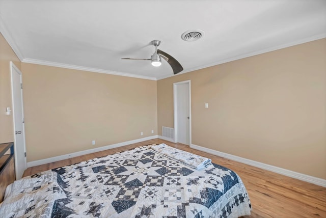 bedroom featuring hardwood / wood-style flooring, ceiling fan, and crown molding