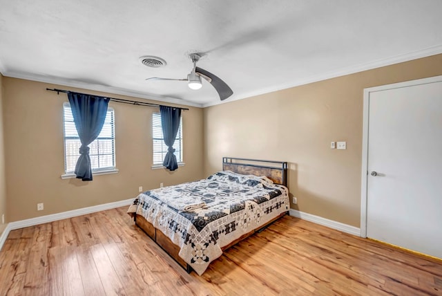 bedroom with hardwood / wood-style floors, ceiling fan, and ornamental molding