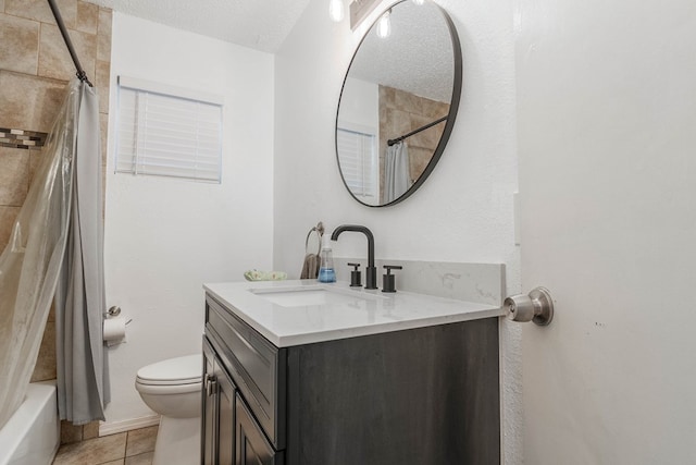 full bathroom with vanity, tile patterned floors, toilet, and a textured ceiling