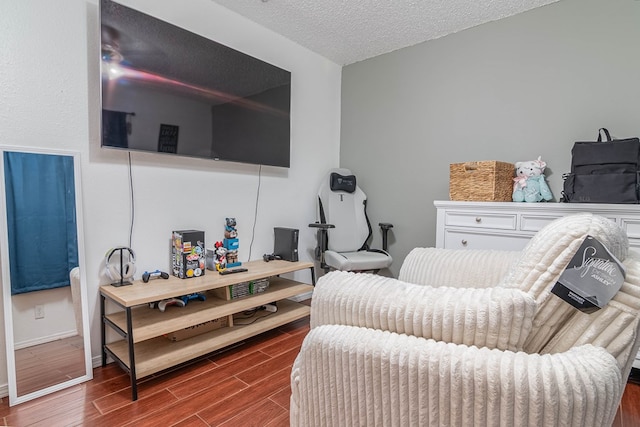 sitting room with a textured ceiling, radiator heating unit, and wood finish floors