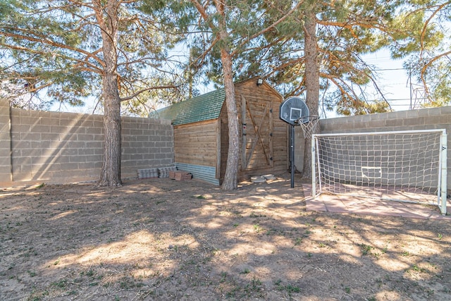 view of yard featuring a shed, an outdoor structure, and fence