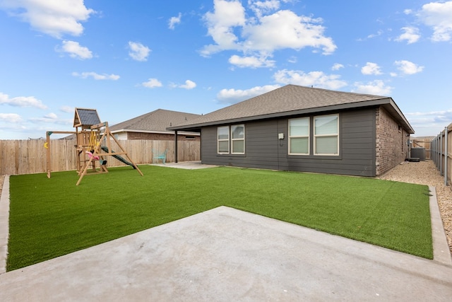 back of house featuring a playground, central air condition unit, a patio area, and a lawn