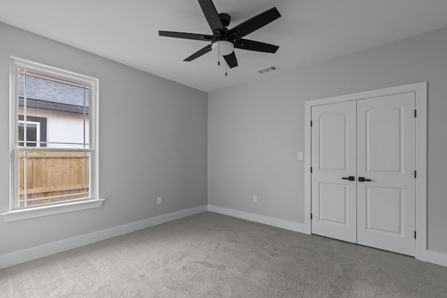 unfurnished bedroom with carpet, a closet, visible vents, and baseboards