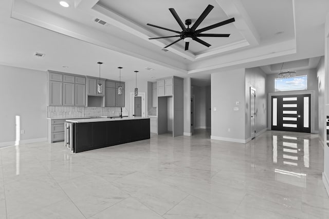 kitchen with visible vents, a tray ceiling, and gray cabinetry