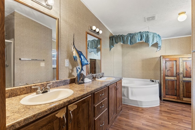 full bathroom featuring a bath, visible vents, a sink, and wood finished floors