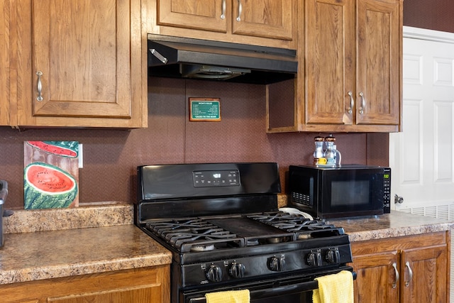 kitchen with black appliances, tasteful backsplash, brown cabinets, and under cabinet range hood