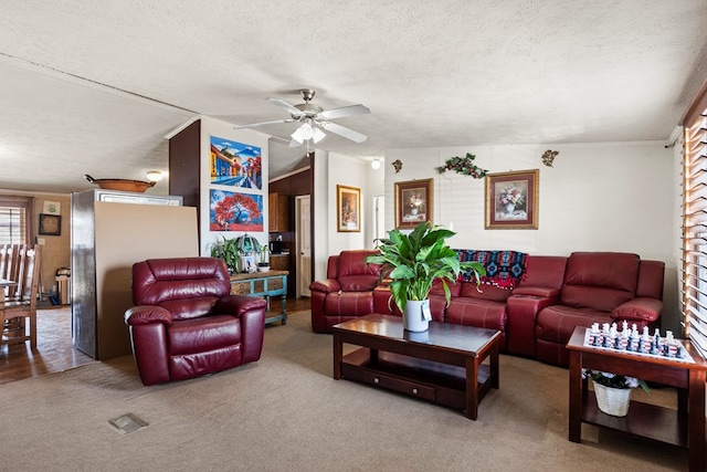 living room with ceiling fan, carpet, vaulted ceiling, and a textured ceiling