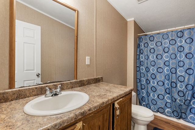 bathroom featuring toilet, curtained shower, ornamental molding, and vanity