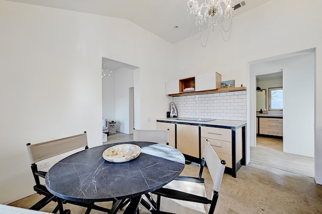 dining area with lofted ceiling and a notable chandelier