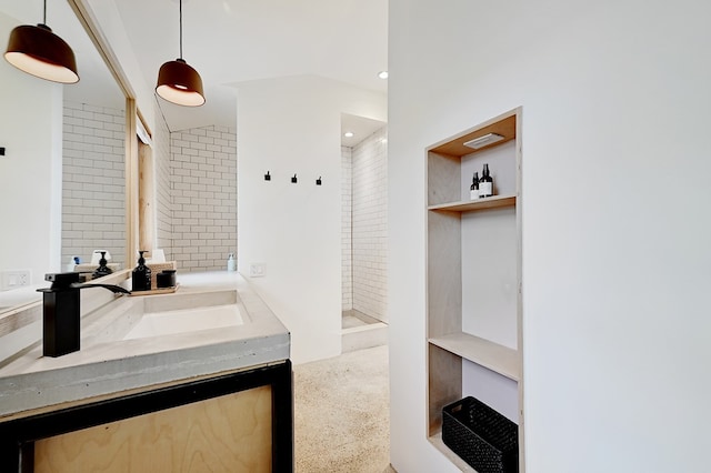 bathroom with vanity, a tile shower, and lofted ceiling