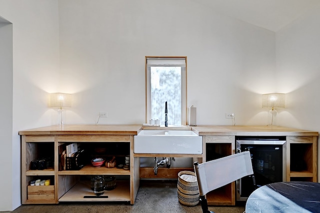 interior space with lofted ceiling, sink, and beverage cooler