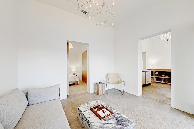 living room featuring a towering ceiling and a notable chandelier