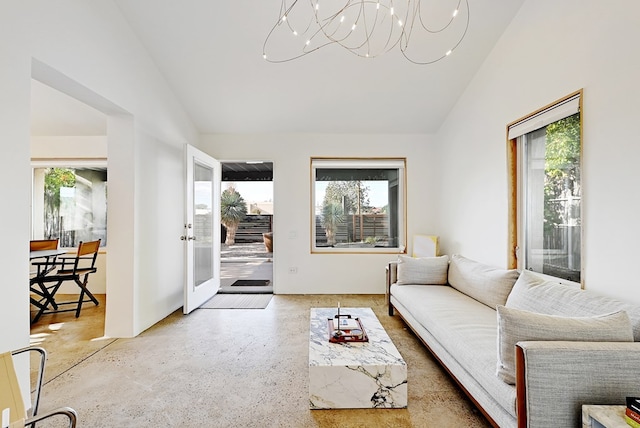 living room with a chandelier, vaulted ceiling, and plenty of natural light